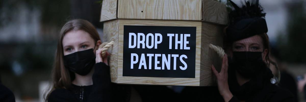 Vaccine equity campaigners carry a mock coffin in London.