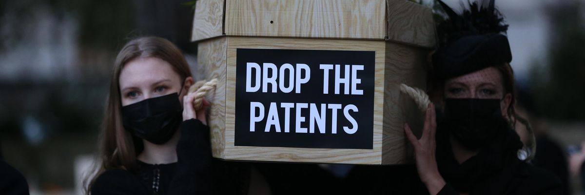 Vaccine equity campaigners carry a mock coffin in London.