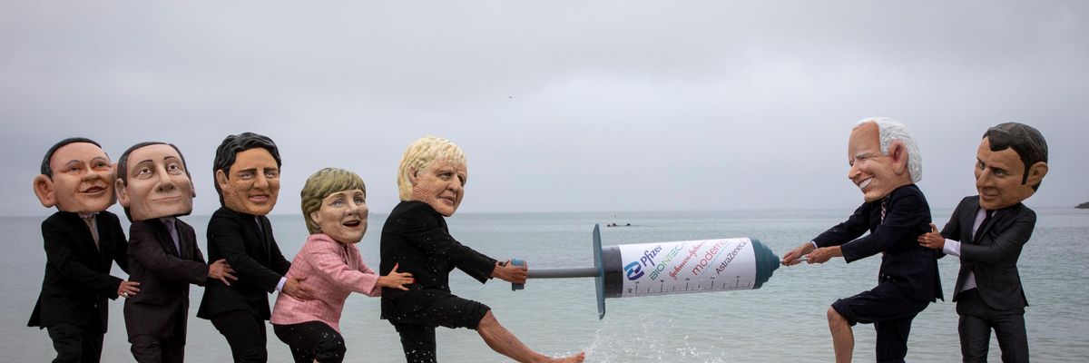 Vaccine equity campaigners posing as G7 leaders tussle over a giant mock syringe