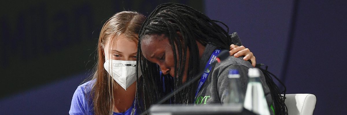 Vanessa Nakate (R) leans on Greta Thunberg