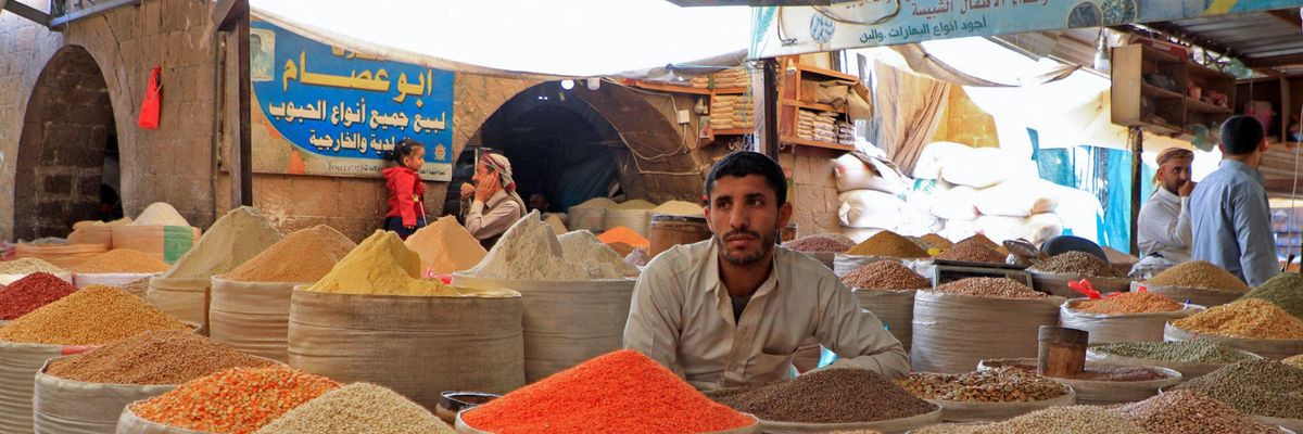 Vendor sells grains at a market in Yemen