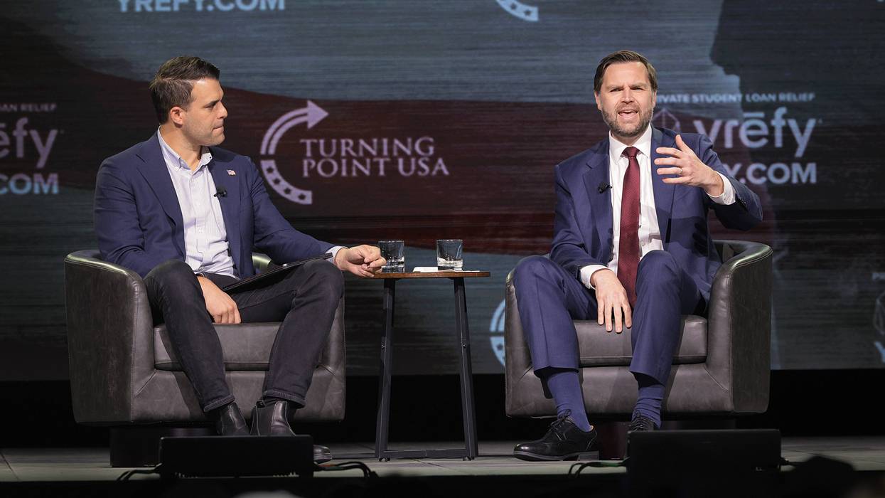 Vice President JD Vance sits in a chair and gestures toward the audience at a TPUSA event in Georgia