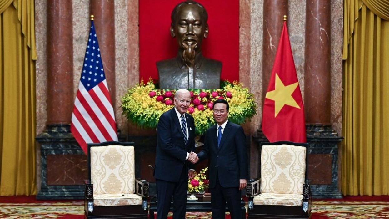 Vietnam's President Vo Van Thuong (R) shakes hands with U.S. President Joe Biden.
