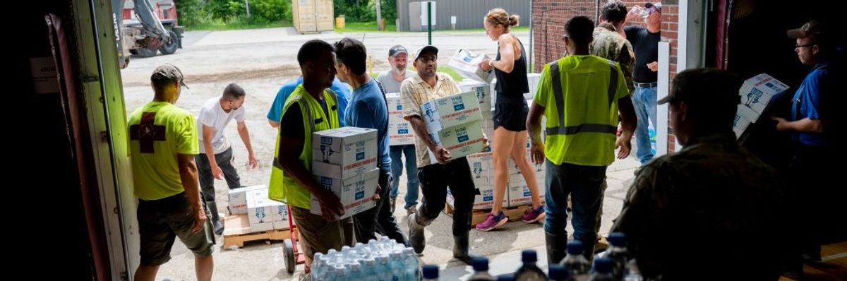 Volunteers and Vermont Army National Guardsmen unload water bottles.