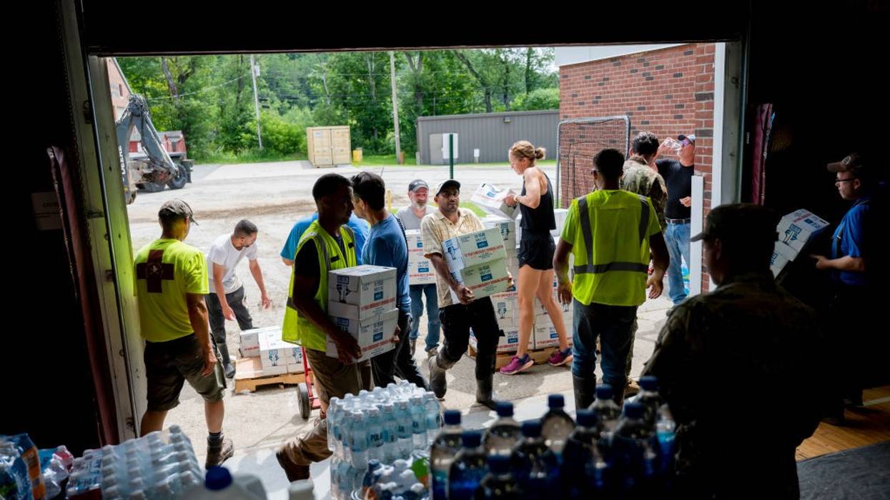 Volunteers and Vermont Army National Guardsmen unload water bottles.
