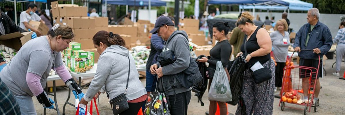 Volunteers hand out groceries to needy families