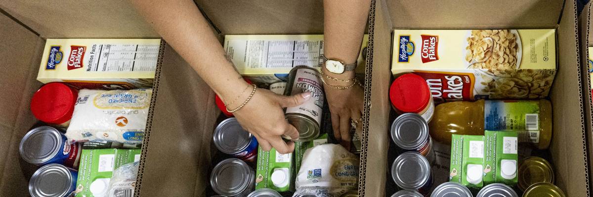 Volunteers pack food bank boxes.