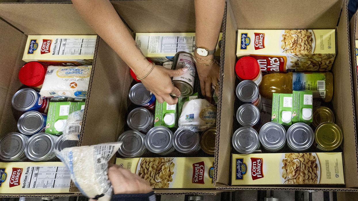 Volunteers pack food bank boxes.