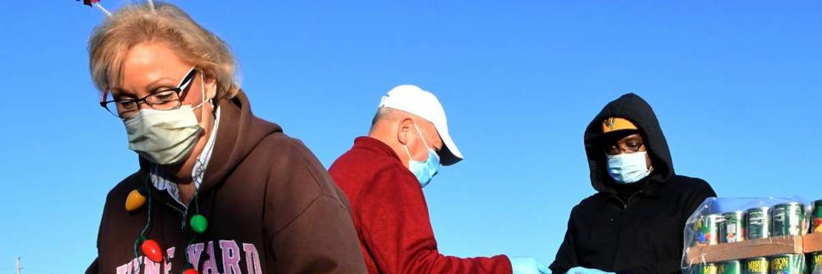 Volunteers prepare food assistance for the needy at the Share Your Christmas food distribution event on December 9, 2020 in Groveland, Florida