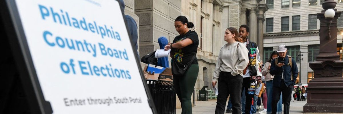 Voters wait in a line to cast their ballots