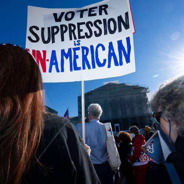 Voting rights protesters hold a sign reading "Voter Suppression Is Un-American" outside the Supreme Court