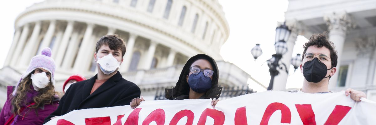 Voting rights protesters hold sign reading "Democracy" in Washington, DC