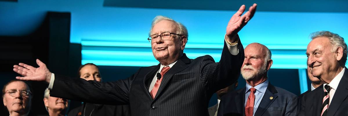 Warren Buffett raises his arms.