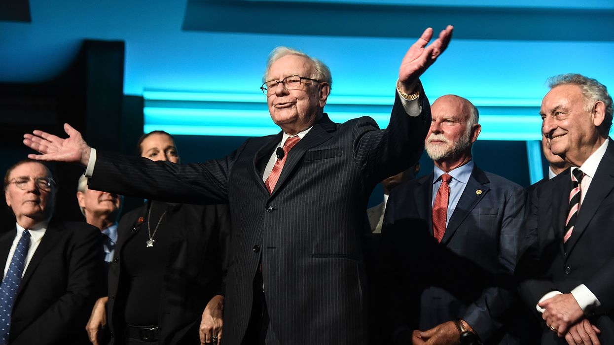 Warren Buffett raises his arms.