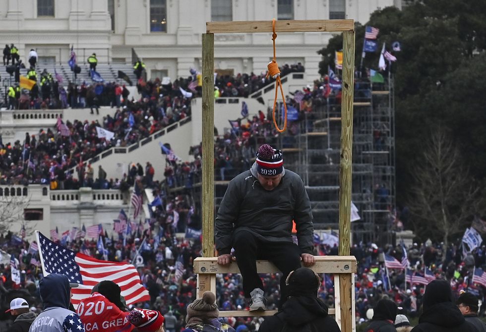 WASHINGTON, DC - JANUARY 6: A man climbs down after being photo
