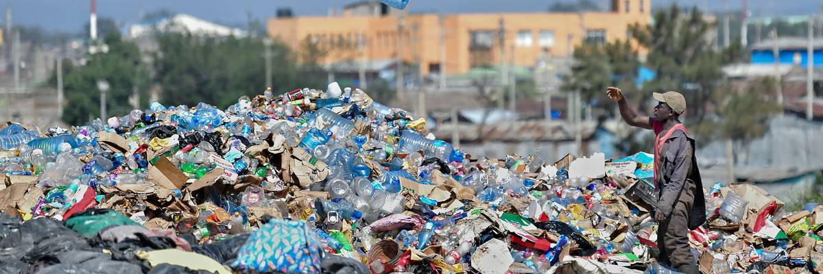 Waste picker sorting through dump for plastic.