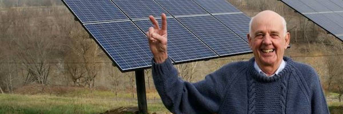 Wendell Berry in front of solar panels.