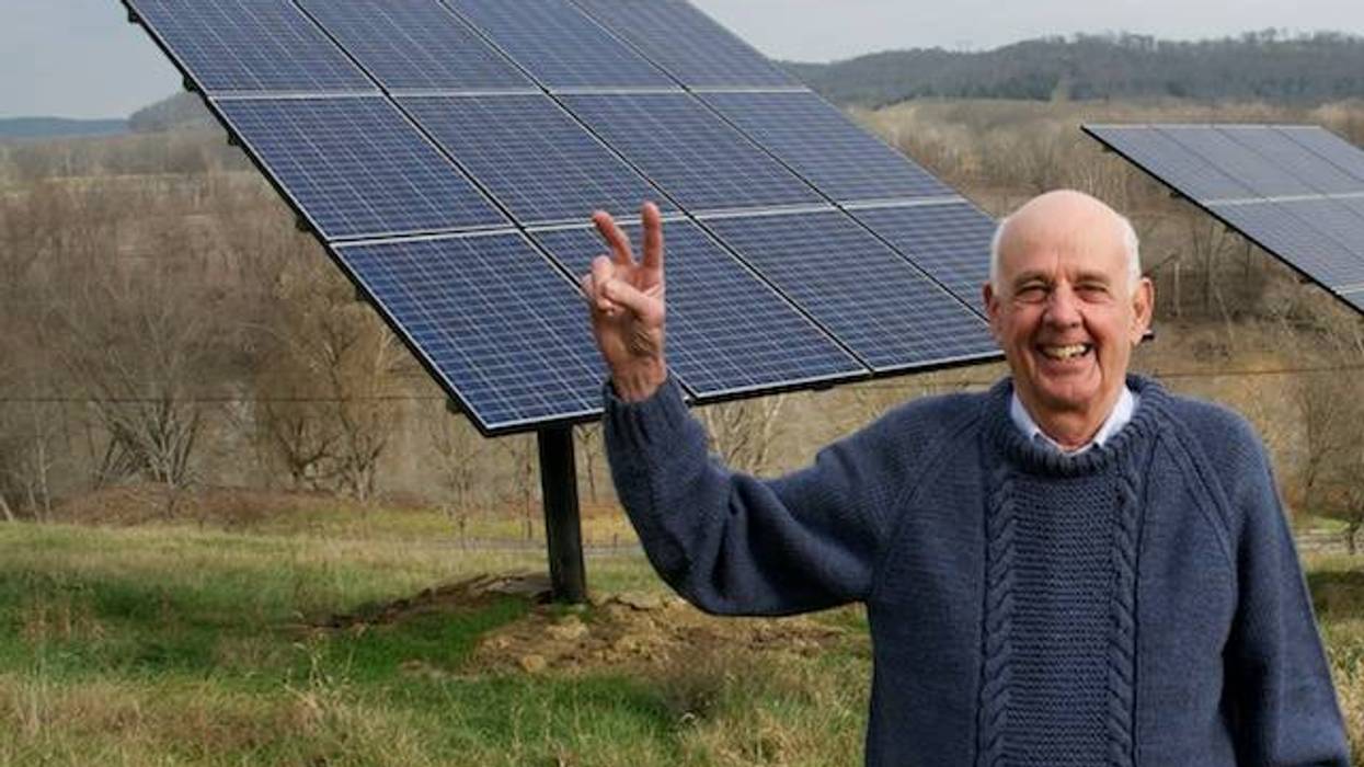 Wendell Berry in front of solar panels.