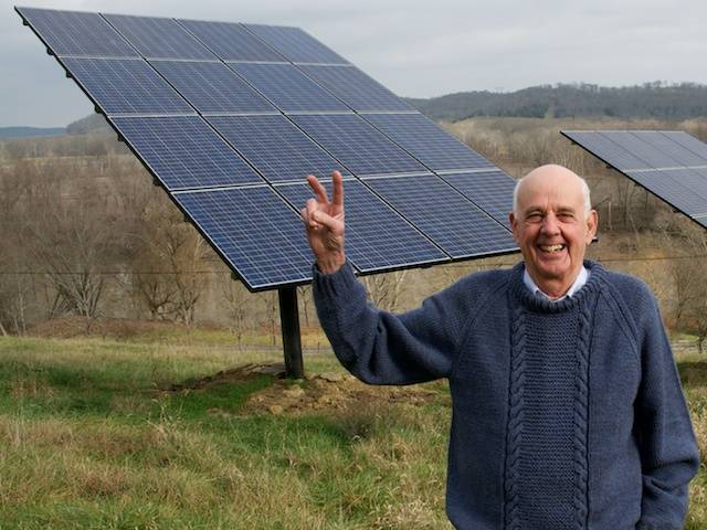 Wendell Berry in front of solar panels.