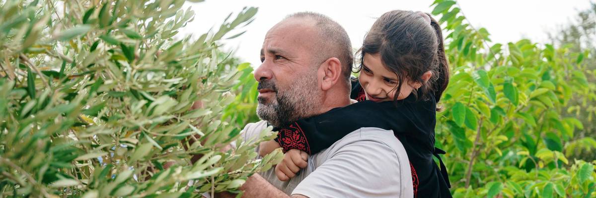 West Bank olive farmer Motaz Bisharat and daughter.