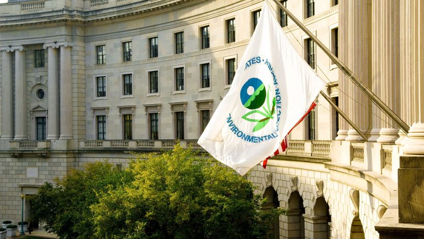 white flag with EPA logo flies outside the agency's  DC headquarters