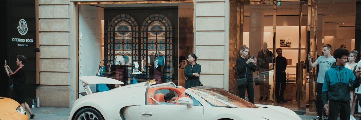 White Porsche 911 parked in front of Versace retail store