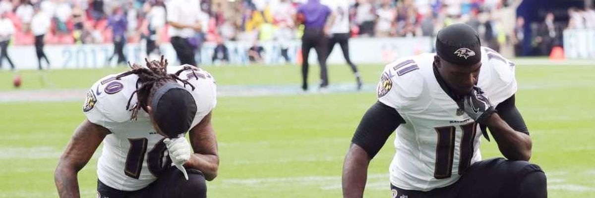 Wide receivers Chris Moore and Breshad Perriman of the Baltimore Ravens kneel 
