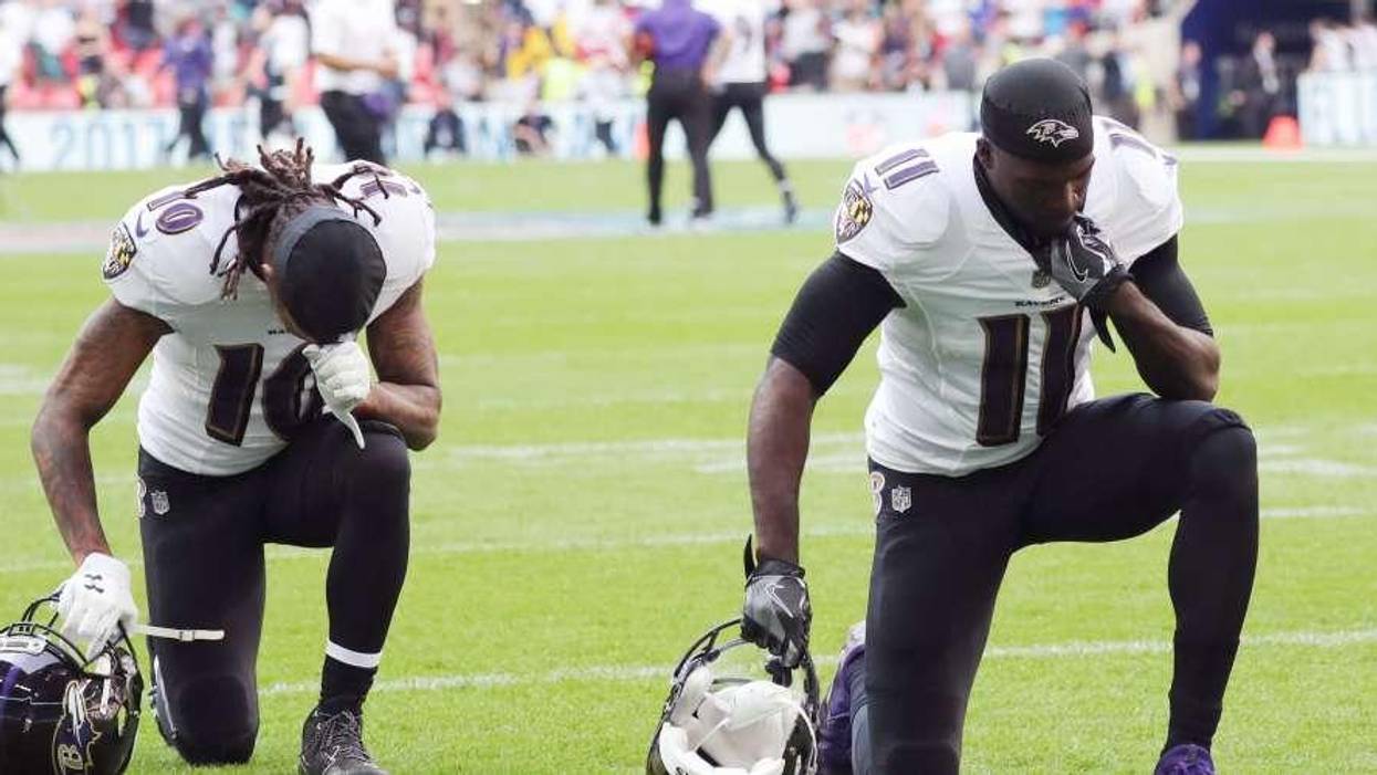 Wide receivers Chris Moore and Breshad Perriman of the Baltimore Ravens kneel
