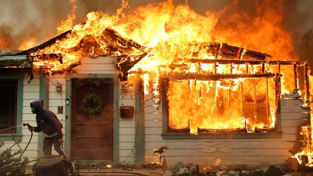 Wildfire burns a house.