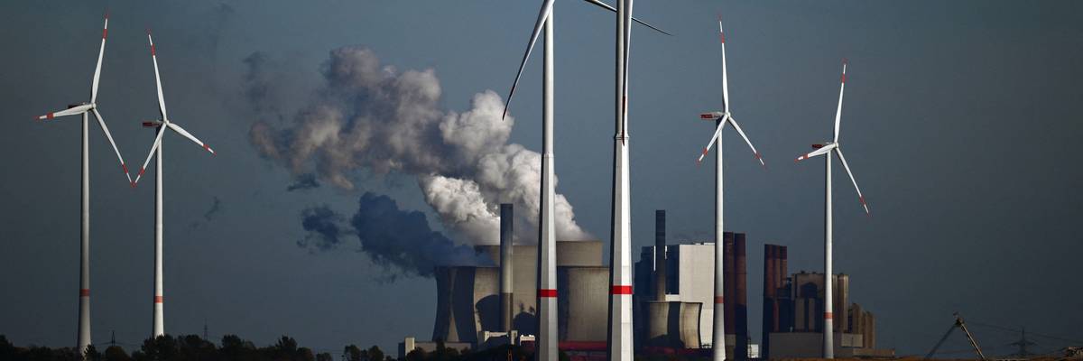 Wind turbines are shown in front of a coal-fired power plant operated by energy giant RWE near Niederaussem, Germany on October 5, 2022.