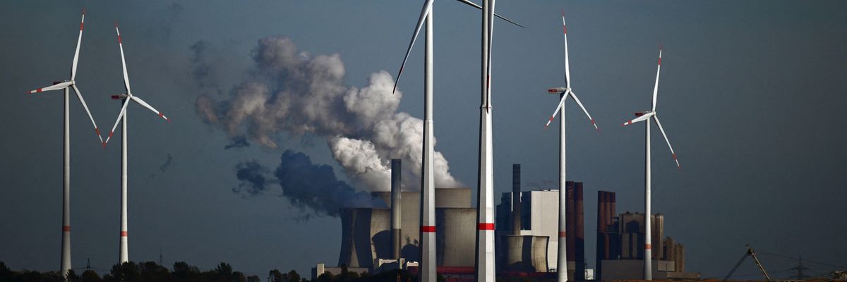 Wind turbines are shown in front of a coal-fired power plant operated by energy giant RWE near Niederaussem, Germany on October 5, 2022.