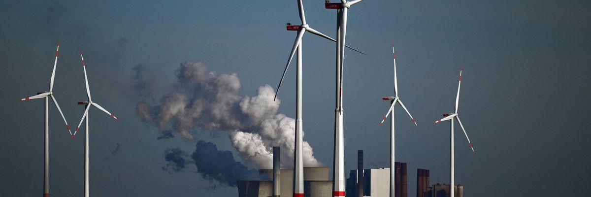 Wind turbines are shown in front of a coal-fired power plant operated by energy giant RWE near Niederaussem, Germany on October 5, 2022.
