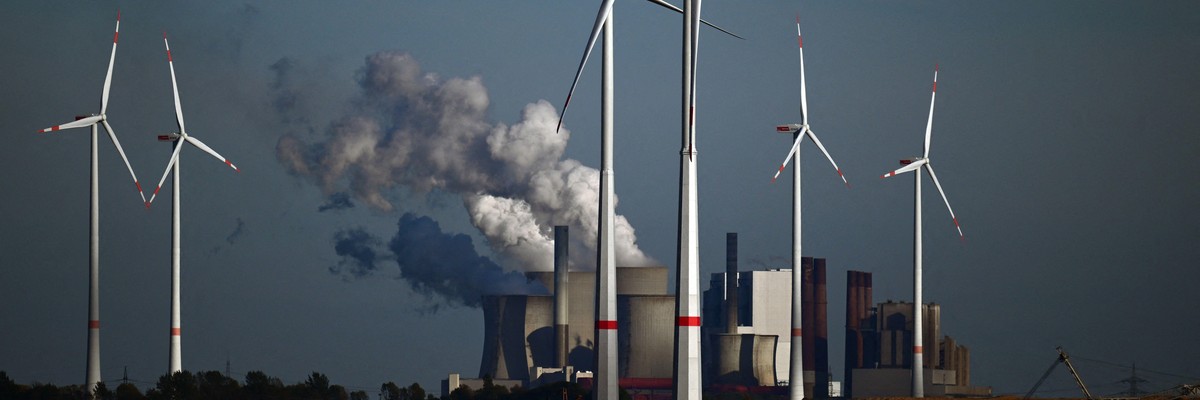 Wind turbines are shown in front of a coal-fired power plant operated by energy giant RWE near Niederaussem, Germany on October 5, 2022.