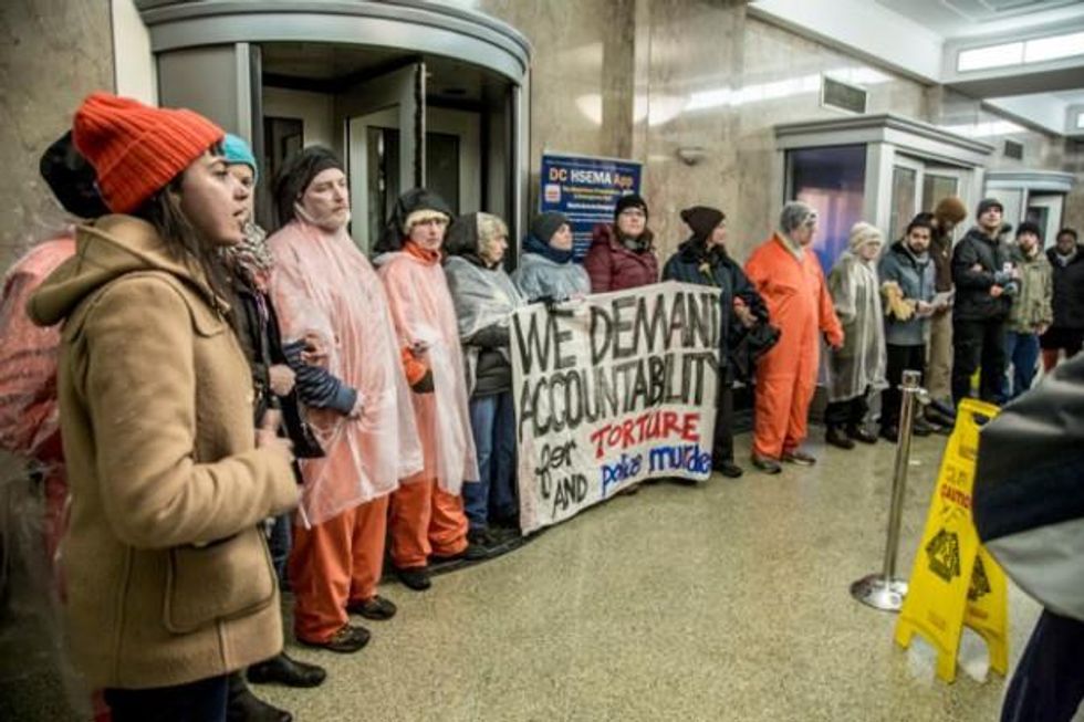 Witness Against Torture members demonstrating in the entrance of DC Metro Police headquarters on January 12, 2015.  (WNV/ Justin Norman)
