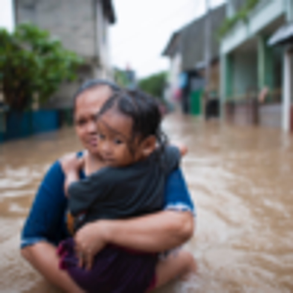 Woman and child in flood in Indonesia. (Photo: World Meteorological Organisation, Flickr/Climate Visuals)