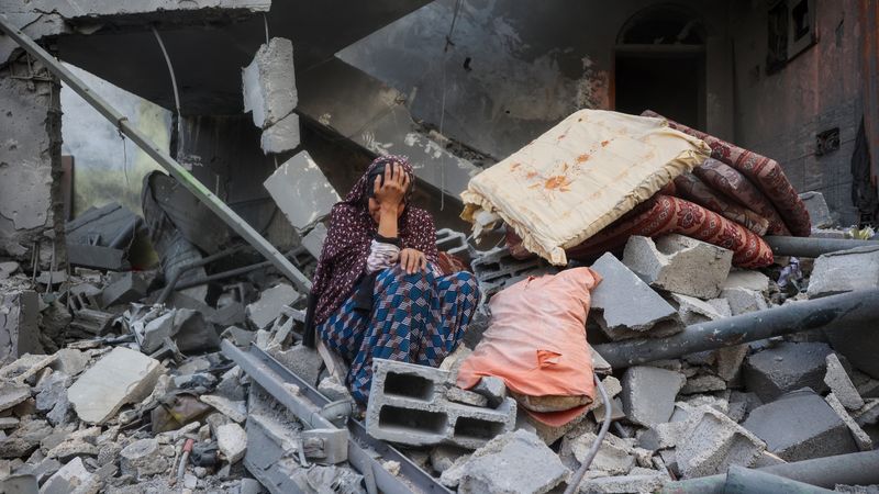 Woman. cries in rubble in Gaza.