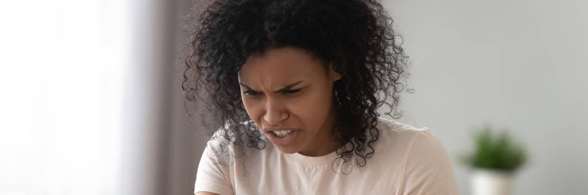 Woman holding smartphone looks frustrated