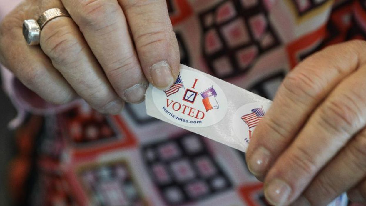 Woman holds an I Voted sticker.