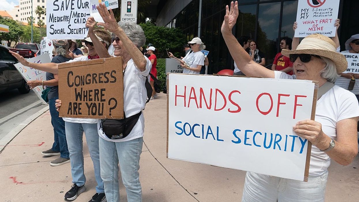 Woman holds sign reading, "Hands off social security."