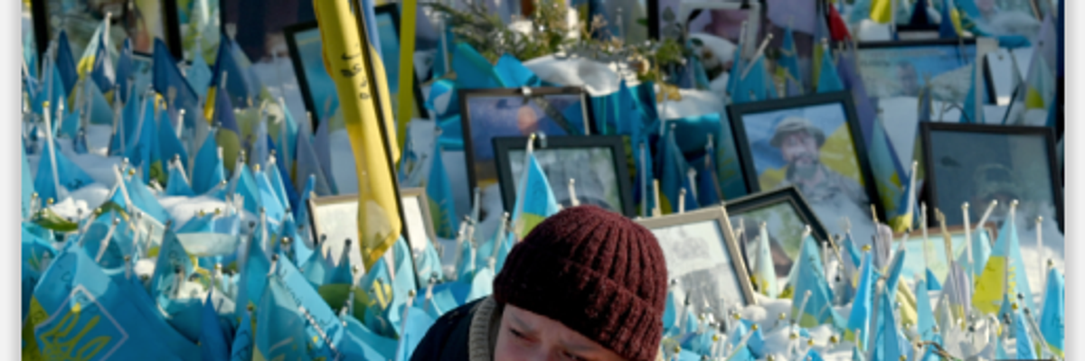 Woman reacts at Kyiv memorial for fallen Ukrainian fighters on third anniversary of Russian invasion