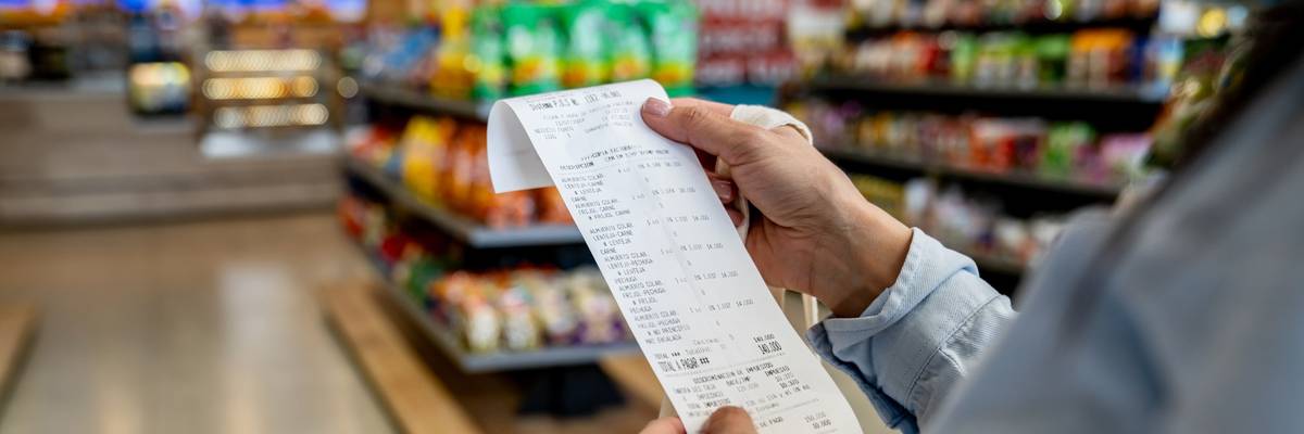 Woman shopping at a convenience store and checking her receipt