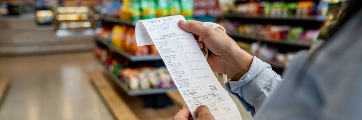 Woman shopping at a convenience store and checking her receipt