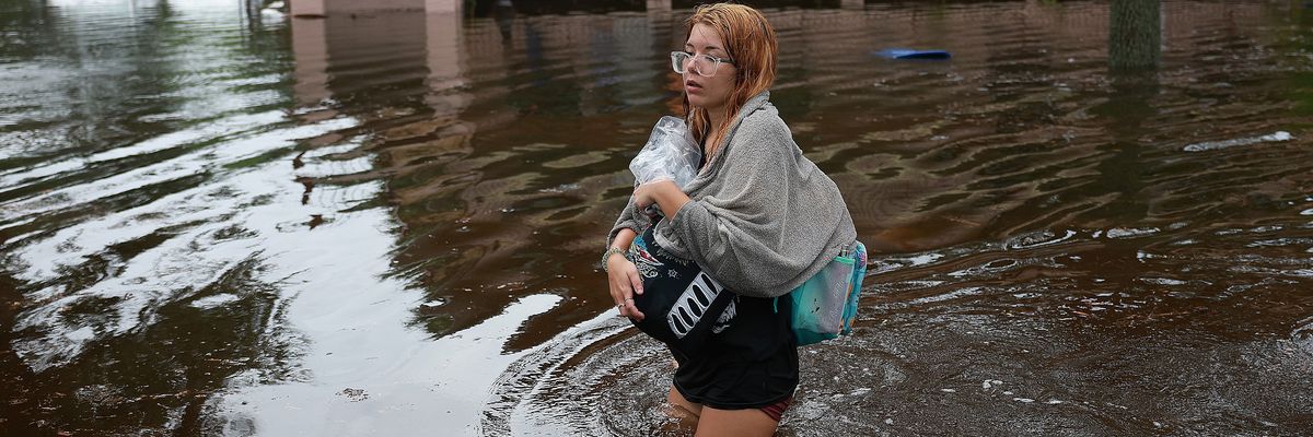 woman wades through flood waters from Hurricane Idalia 