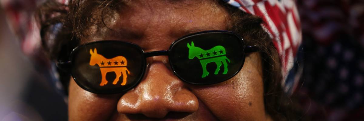 Woman wears sunglasses with Democratic donkeys on the lenses.