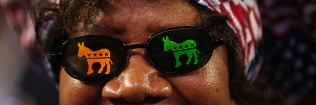 Woman wears sunglasses with Democratic donkeys on the lenses.