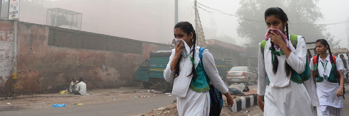 Women cover their faces from air pollution in Delhi, India.