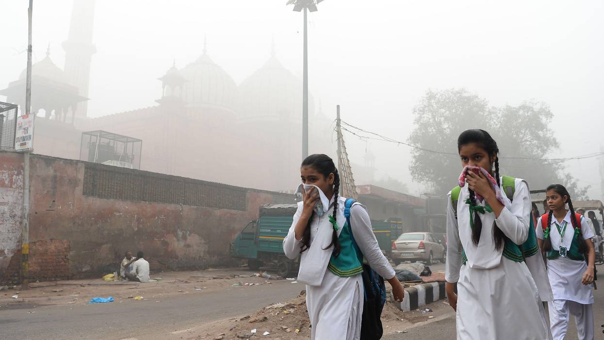 Women cover their faces from air pollution in Delhi, India.