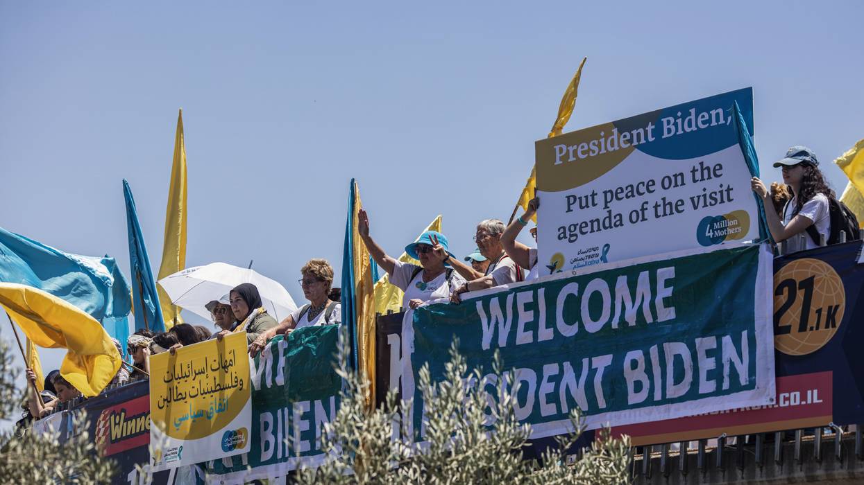 Women dressed in blue and yellow hold up signs.
