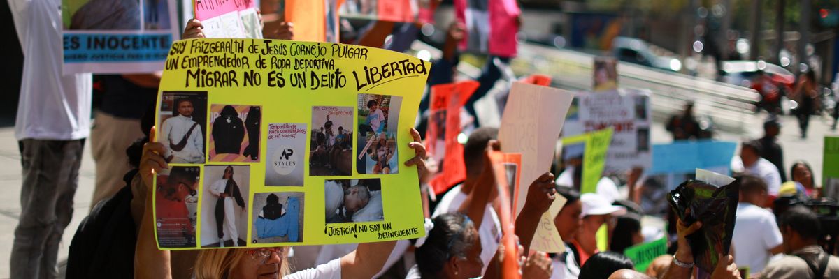women holds poster; other people hold posters next to her