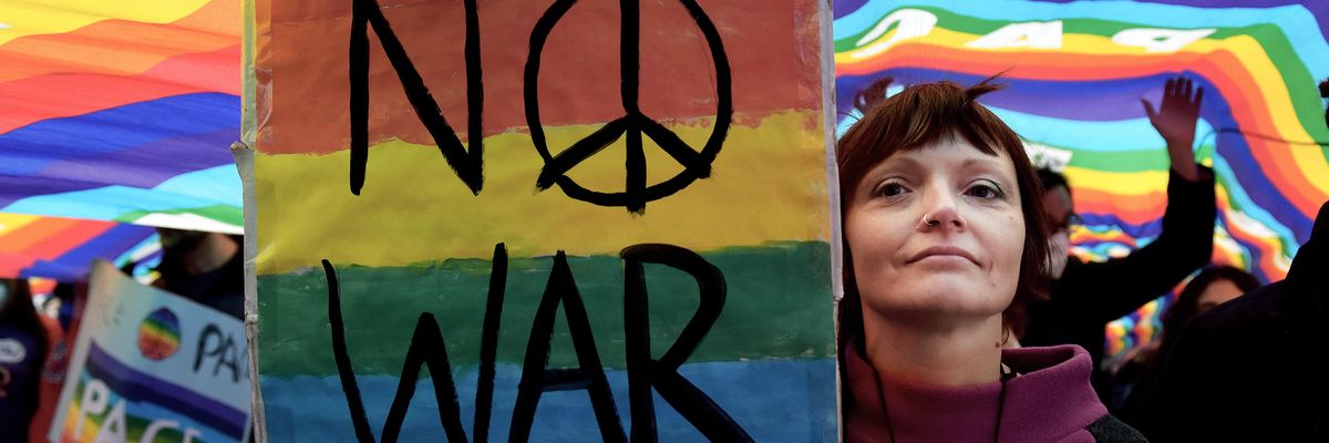 Women holds sign that reads "No War" to protest war in Ukraine